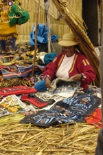 Local Uros woman selling crafts (looking happy having sold a cushion cover), Uros floating islands