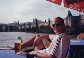 Ian enjoying a beer with a view of Charles Bridge and the castle